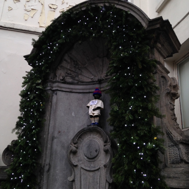 That's the Manneken Pis!  Yes, he isn't very impressive and is dressed like a runner for the marathon that took place that evening.   Still not sure what the fuss is about, but no trip to Brussels is complete without a picture of this little guy peeing.
